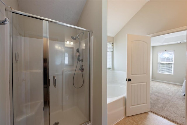 full bathroom with vaulted ceiling, a bath, and a stall shower