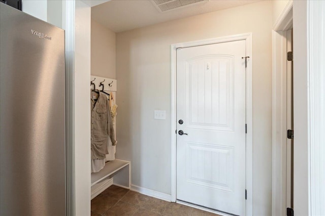 mudroom featuring visible vents, baseboards, and dark tile patterned floors