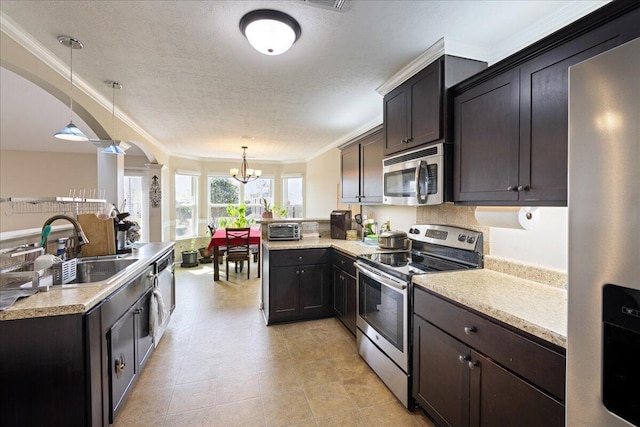 kitchen with a sink, stainless steel appliances, arched walkways, and light countertops