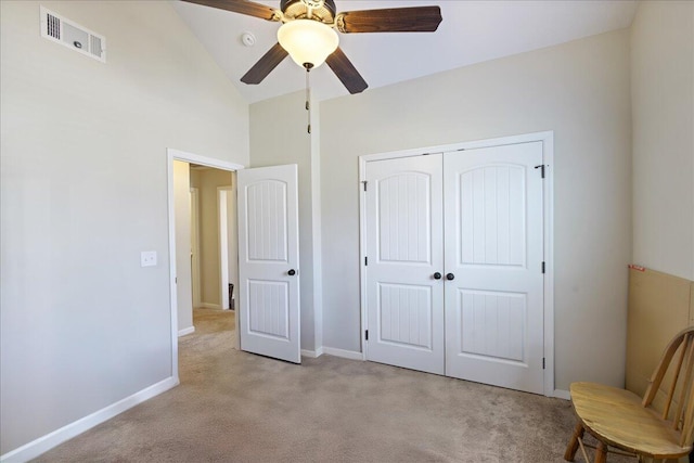 unfurnished bedroom featuring lofted ceiling, carpet, visible vents, and a closet