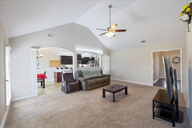 carpeted living area with visible vents, arched walkways, high vaulted ceiling, and ceiling fan