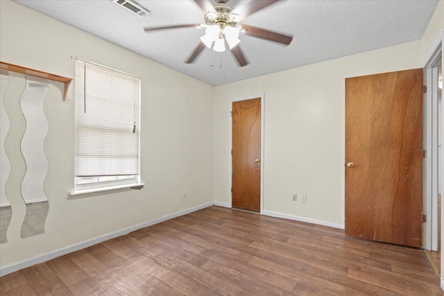 unfurnished bedroom with ceiling fan, a textured ceiling, and light wood-type flooring