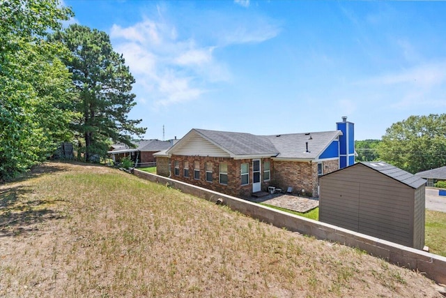 rear view of property with a yard and a shed