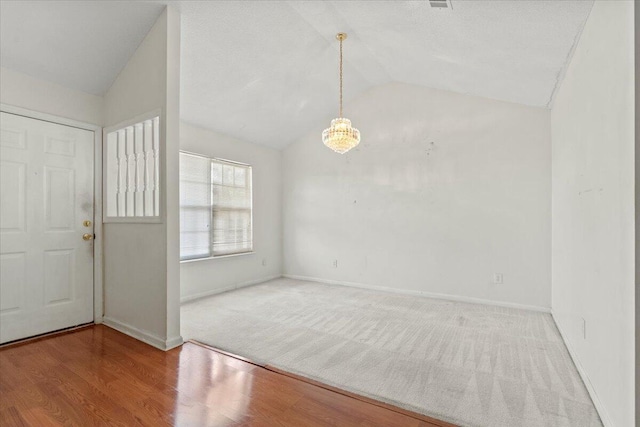 entrance foyer featuring a notable chandelier, wood-type flooring, and lofted ceiling