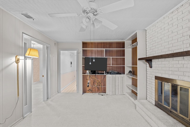 118 E Hale St, Augusta, GA 30901 - unfurnished living room featuring ceiling fan, a fireplace, crown molding, carpet floors, and a textured ceiling