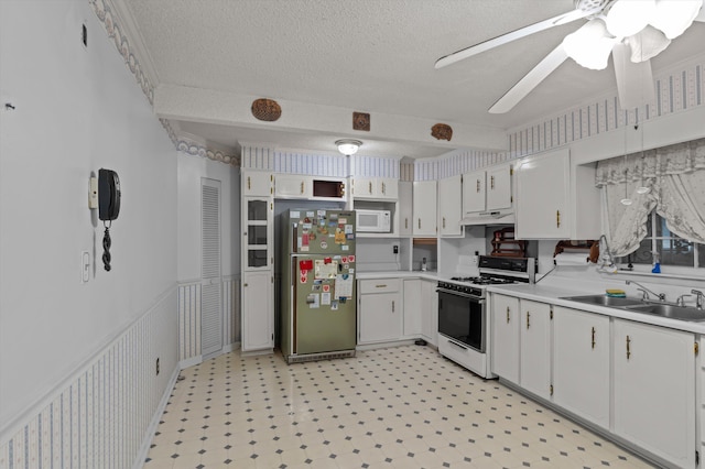 118 E Hale St, Augusta, GA 30901 - kitchen featuring white appliances, a sink, under cabinet range hood, light countertops, and a textured ceiling