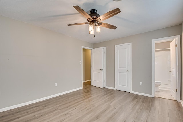 unfurnished bedroom featuring light wood-style flooring, ensuite bath, baseboards, and ceiling fan
