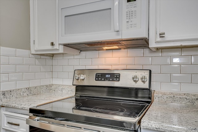 kitchen with stainless steel electric range oven, white microwave, white cabinets, and tasteful backsplash