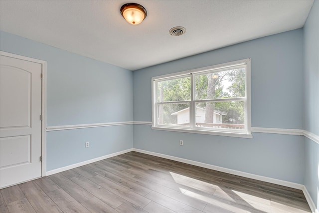 spare room featuring wood finished floors and baseboards