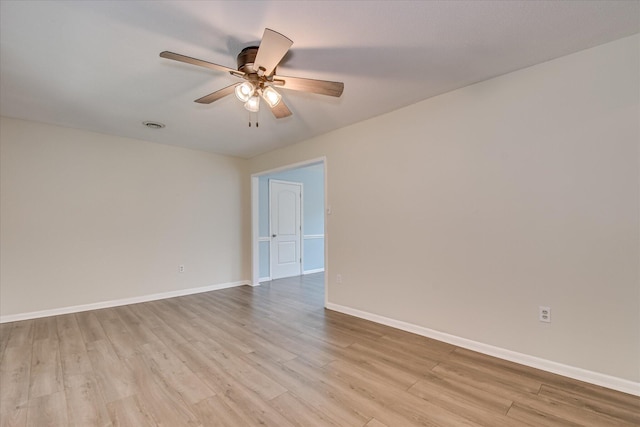 spare room featuring light wood-type flooring, ceiling fan, and baseboards