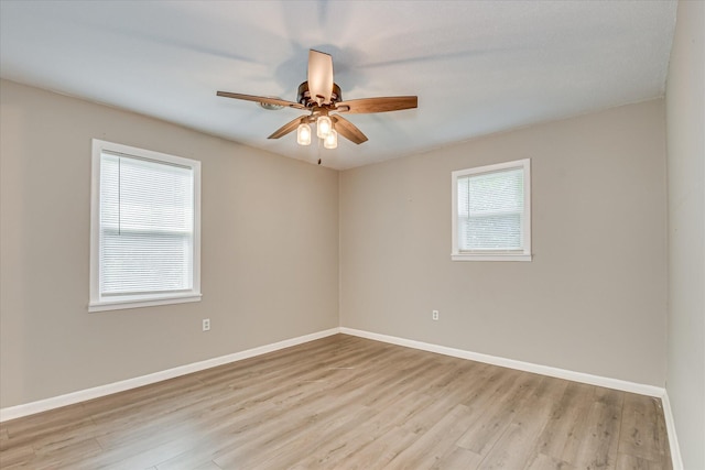 empty room featuring wood finished floors, baseboards, and a ceiling fan