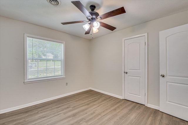 unfurnished bedroom with light wood finished floors, baseboards, and a ceiling fan
