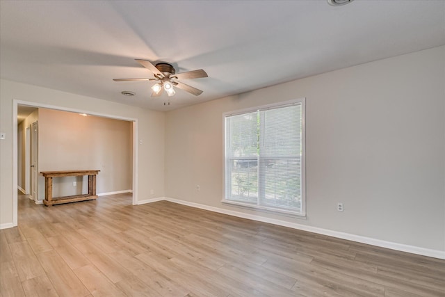 spare room with ceiling fan, baseboards, and light wood-style flooring