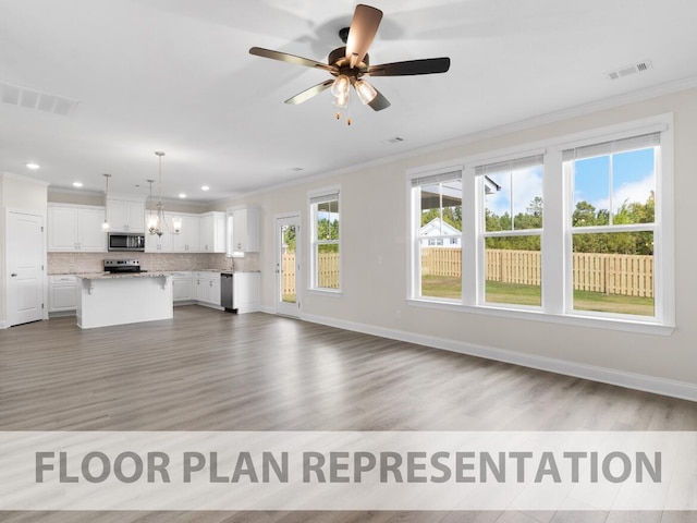 unfurnished living room featuring ornamental molding, visible vents, and wood finished floors