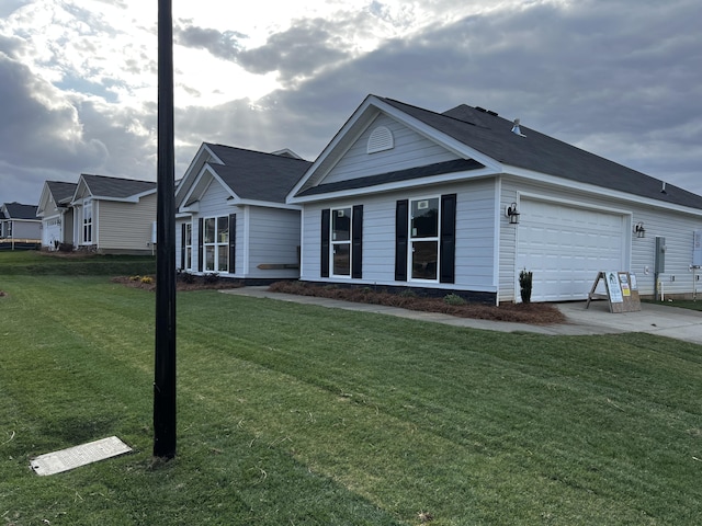 single story home featuring driveway, a front lawn, and an attached garage