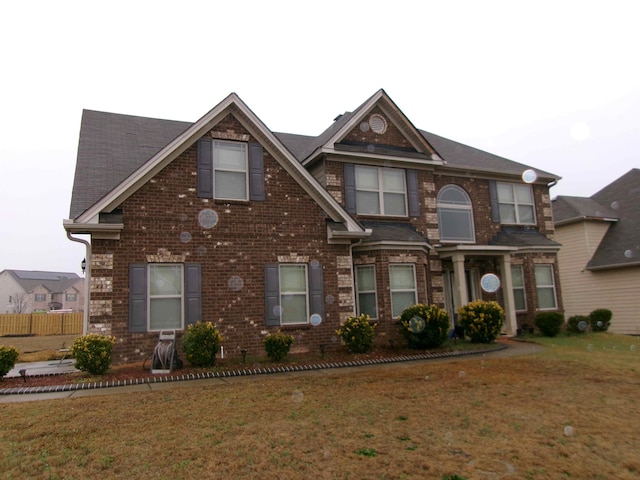 view of front of house featuring brick siding and a front lawn