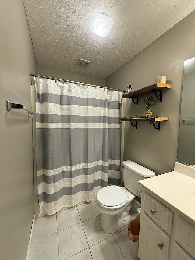 bathroom with a textured ceiling, visible vents, toilet, and vanity