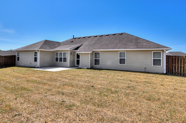 2731 Ashton Dr, Hephzibah, GA 30815 - back of property featuring a fenced backyard, a patio, a yard, and roof with shingles