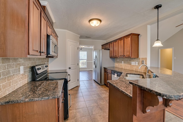 2731 Ashton Dr, Hephzibah, GA 30815 - kitchen featuring brown cabinets, appliances with stainless steel finishes, a sink, a breakfast bar area, and a peninsula
