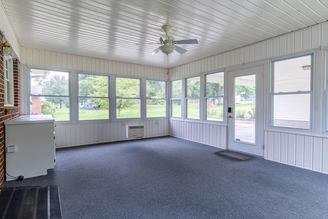 unfurnished sunroom featuring ceiling fan and a wall mounted air conditioner