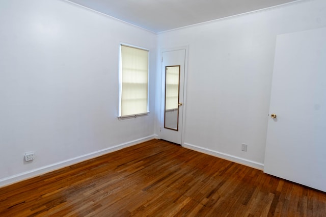 empty room featuring crown molding and dark hardwood / wood-style flooring