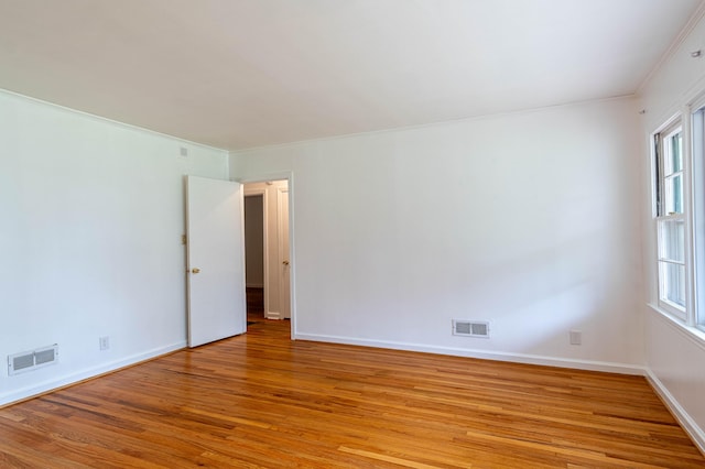 unfurnished room featuring crown molding, plenty of natural light, and light hardwood / wood-style floors