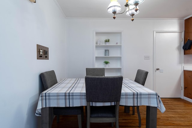 dining area with built in shelves, hardwood / wood-style floors, and a chandelier