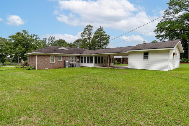 back of house featuring central AC unit and a yard