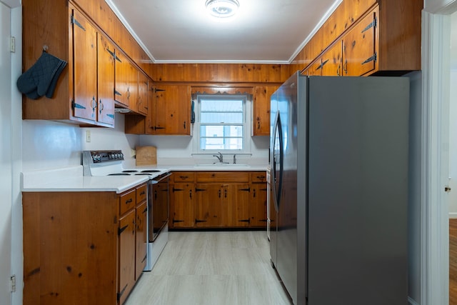 kitchen with white range with electric cooktop, crown molding, sink, and stainless steel refrigerator