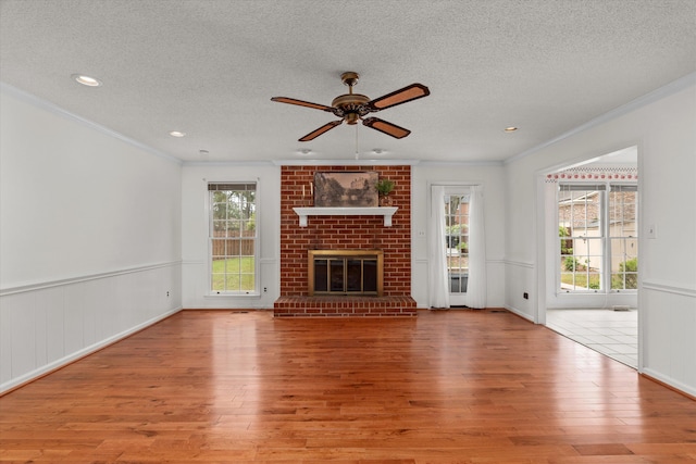 114 Sigman Pl, Martinez, GA 30907 - unfurnished living room with a textured ceiling, wood finished floors, ornamental molding, a ceiling fan, and a fireplace