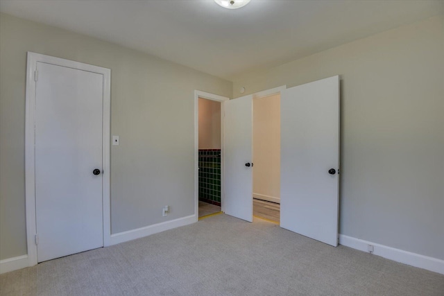 unfurnished bedroom with baseboards and carpet flooring