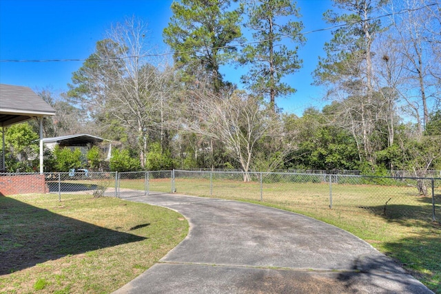 surrounding community with a lawn, driveway, and fence