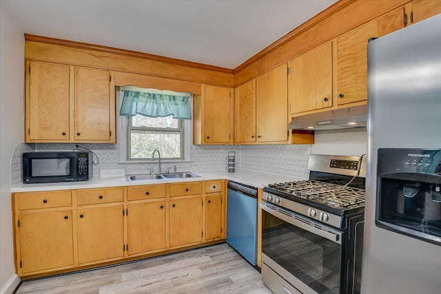 kitchen featuring under cabinet range hood, backsplash, appliances with stainless steel finishes, and a sink