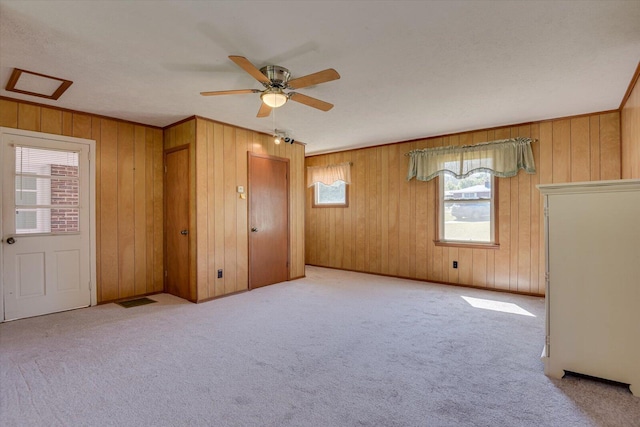 spare room featuring a ceiling fan, carpet, visible vents, and ornamental molding