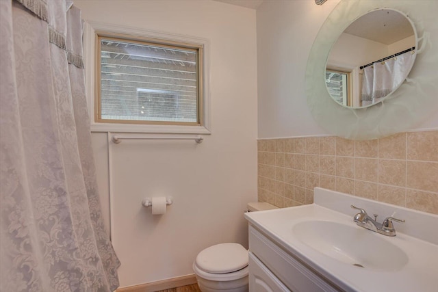 bathroom with tile walls, toilet, vanity, and a shower with curtain