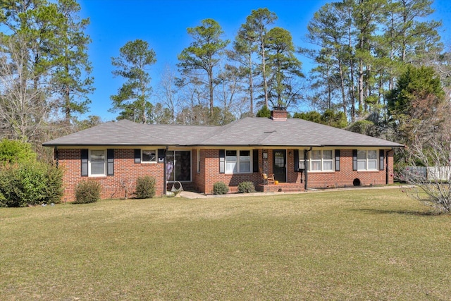 ranch-style house featuring a front yard, brick siding, and a chimney