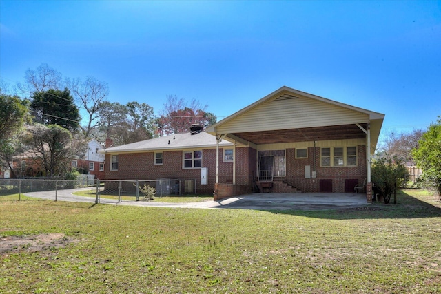 rear view of property featuring a patio, a lawn, brick siding, and fence