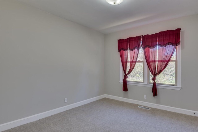 carpeted empty room with visible vents and baseboards