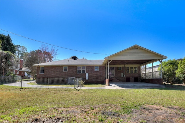 back of property featuring brick siding, fence, a patio area, a lawn, and a carport