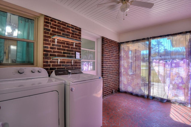 laundry area featuring a ceiling fan, separate washer and dryer, wooden ceiling, brick wall, and laundry area