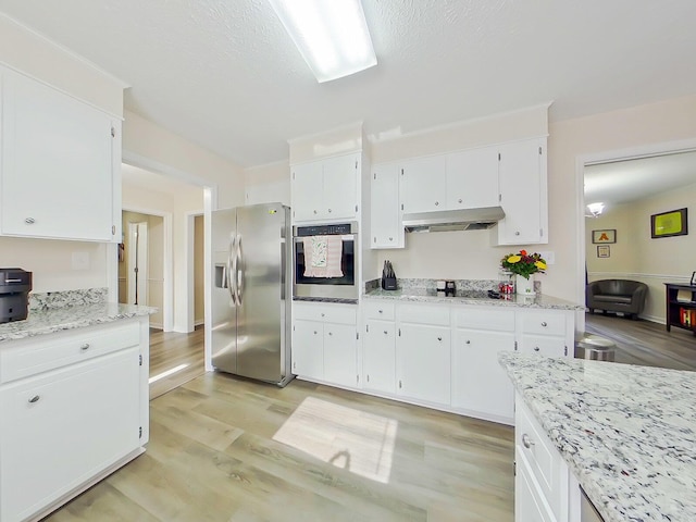 kitchen with white cabinets, light stone countertops, stainless steel appliances, light wood-type flooring, and under cabinet range hood