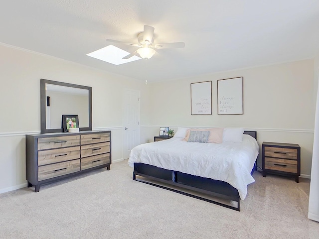 bedroom with a skylight, carpet flooring, ceiling fan, and baseboards
