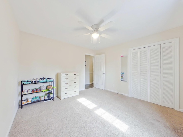 carpeted bedroom featuring a closet, a ceiling fan, and baseboards