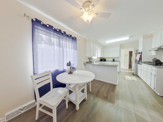 dining space featuring light wood-style flooring, visible vents, and a ceiling fan