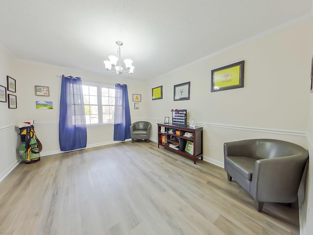 living area featuring light wood-type flooring, crown molding, baseboards, and an inviting chandelier