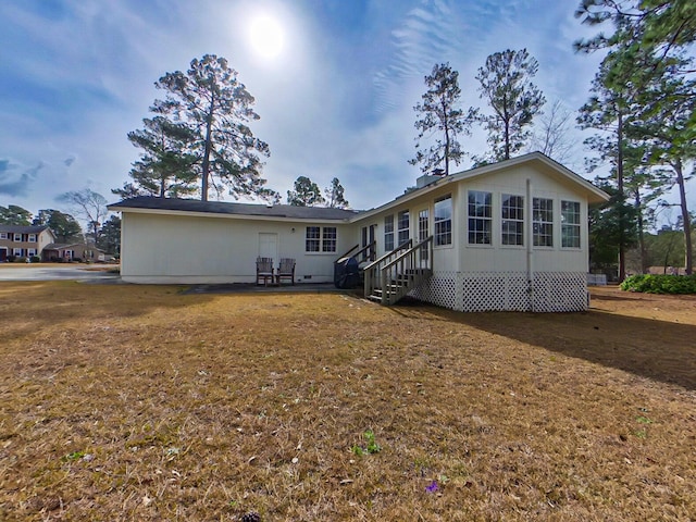 back of property with entry steps, a yard, and a patio area