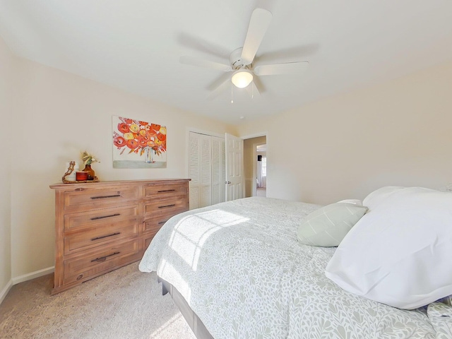 bedroom with ceiling fan, a closet, baseboards, and light colored carpet