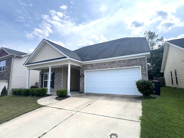 view of front of home featuring covered porch, a garage, and a front lawn