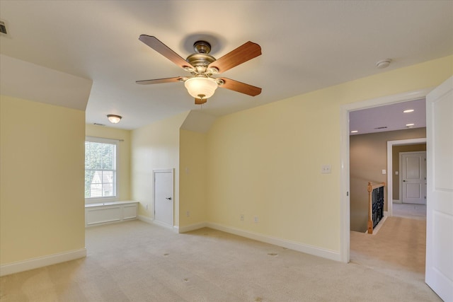 spare room featuring a ceiling fan, light colored carpet, baseboards, recessed lighting, and a fireplace