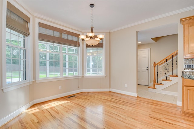 empty room featuring light wood-style floors, a chandelier, crown molding, stairs, and baseboards